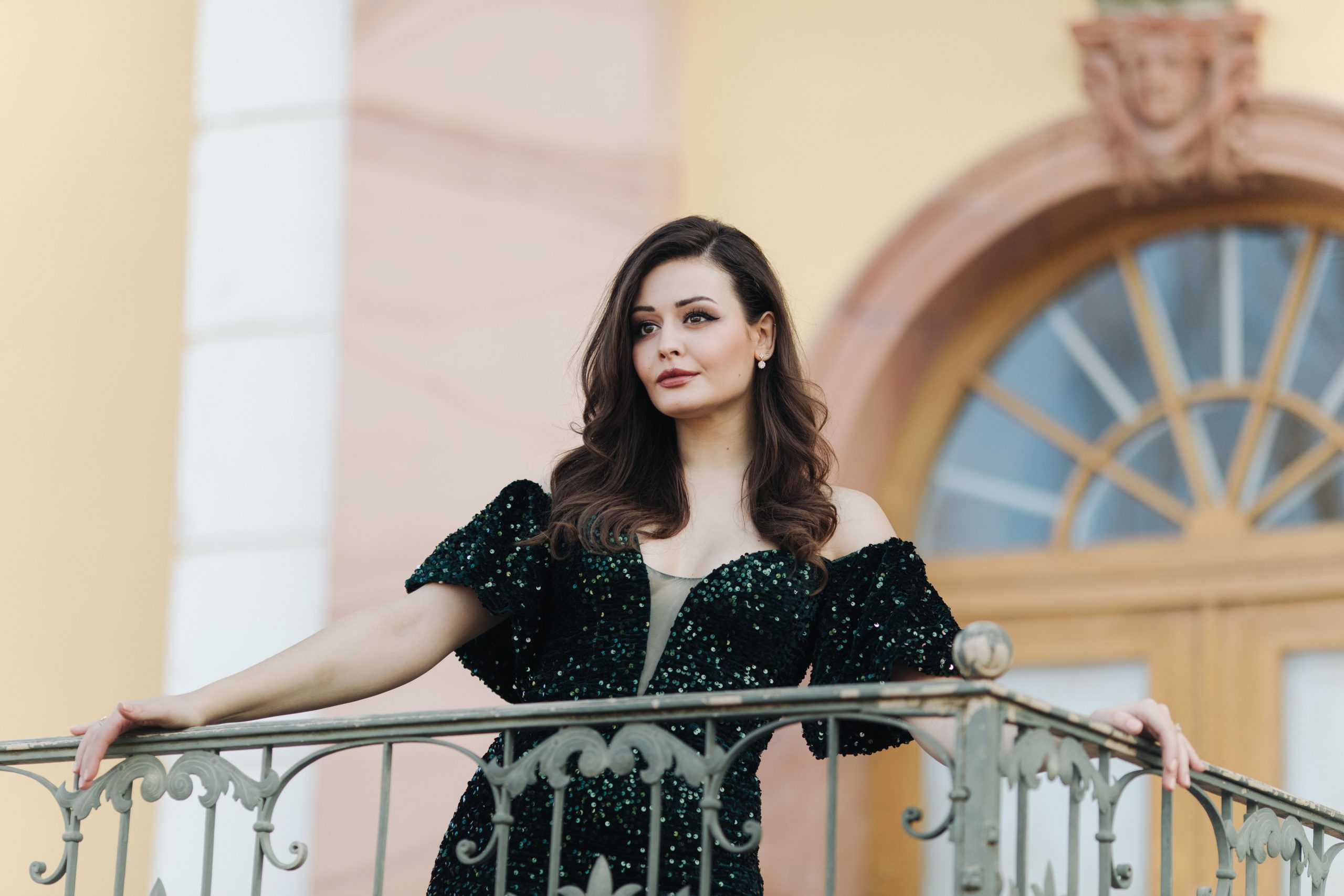 Femme élégante en robe verte sur balcon stylisé
