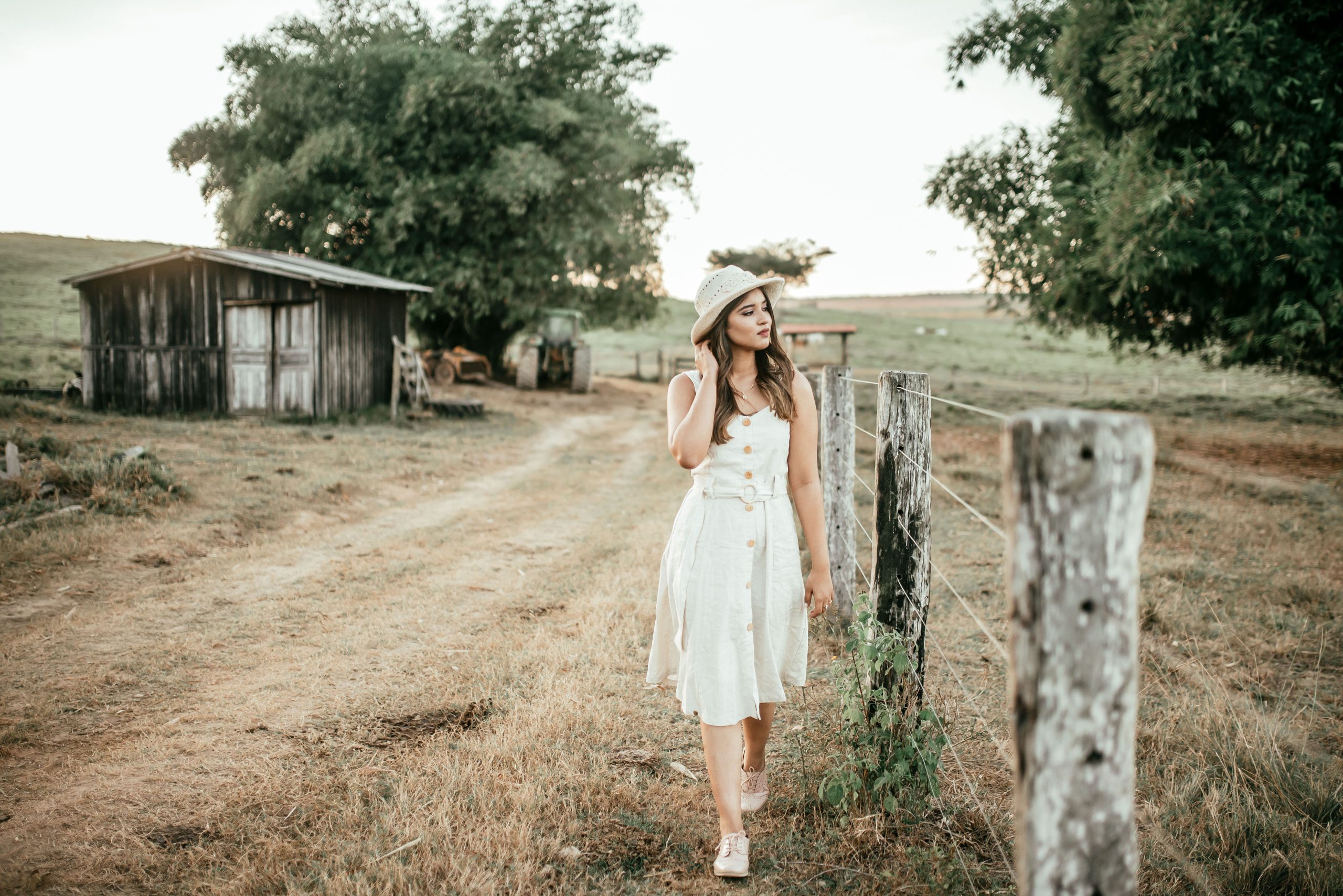 Jeune femme en robe blanche chemin rustique