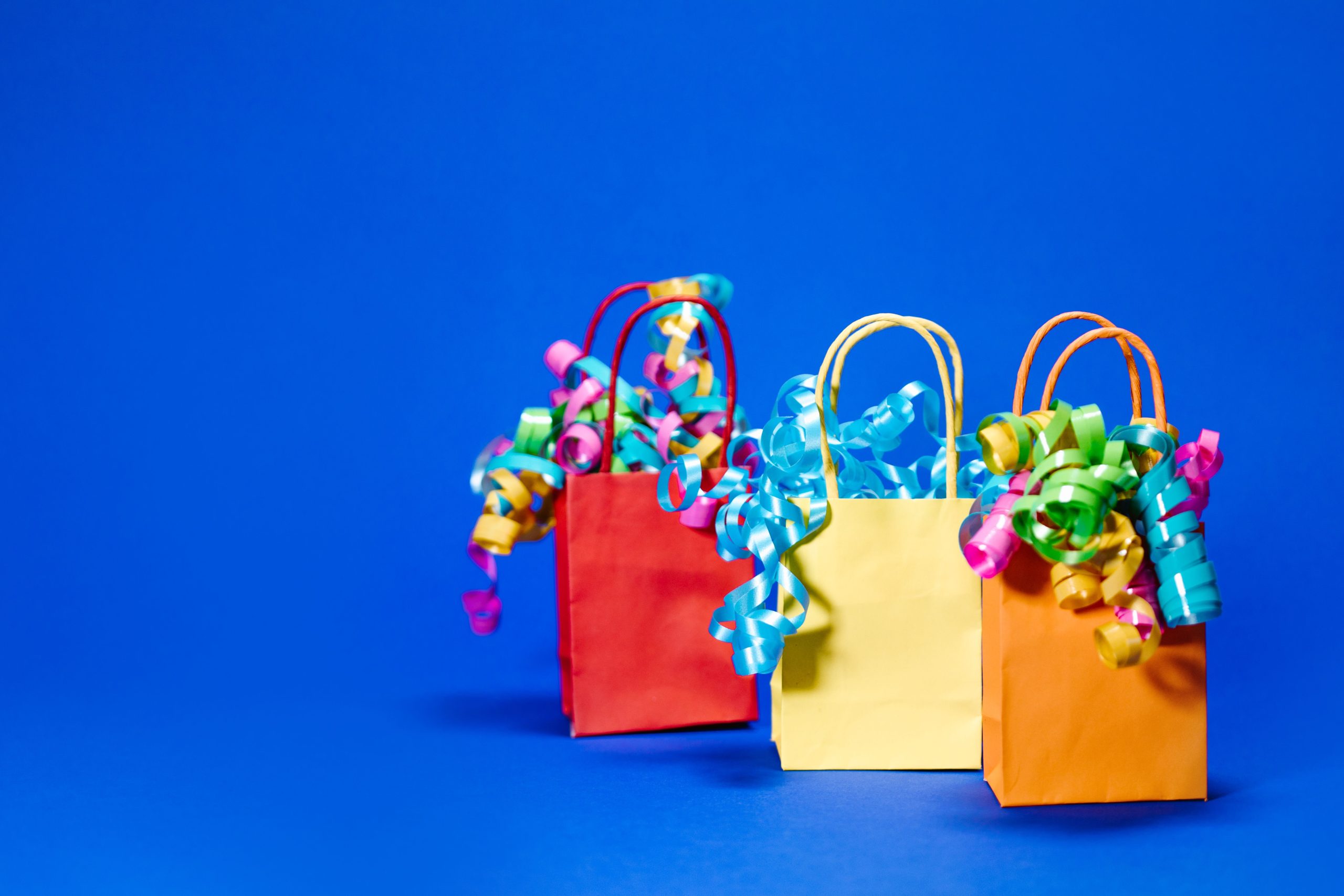 Sacs cadeaux colorés avec rubans frisés bleus