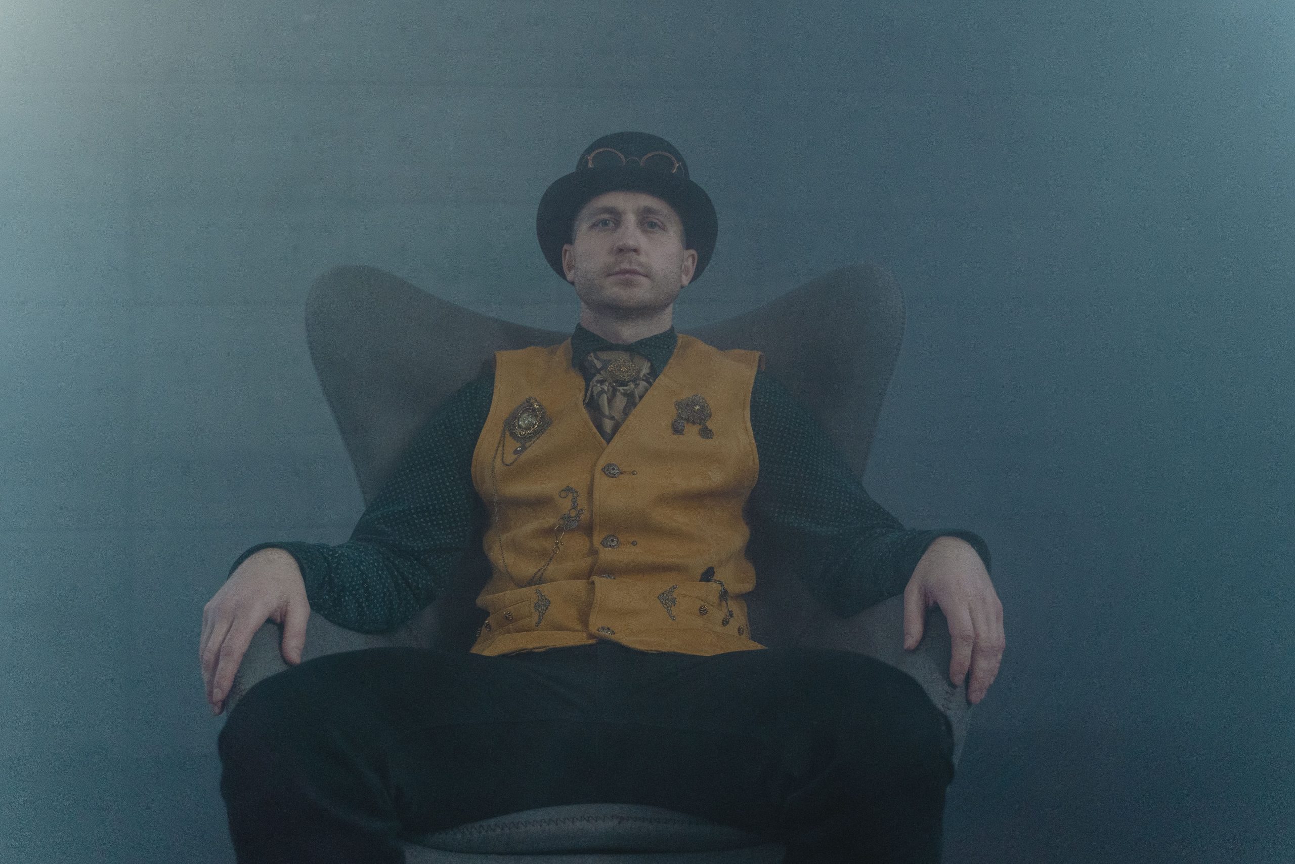 Homme assis portant une veste steampunk vintage