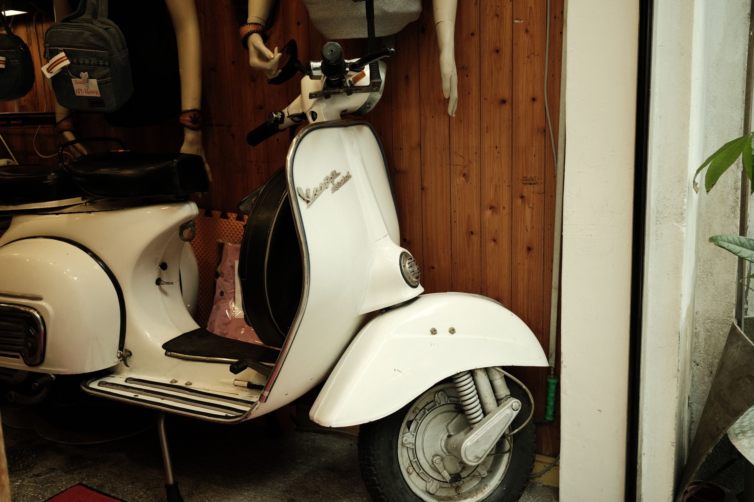 Scooter blanc vintage avec accessoires et mannequins.