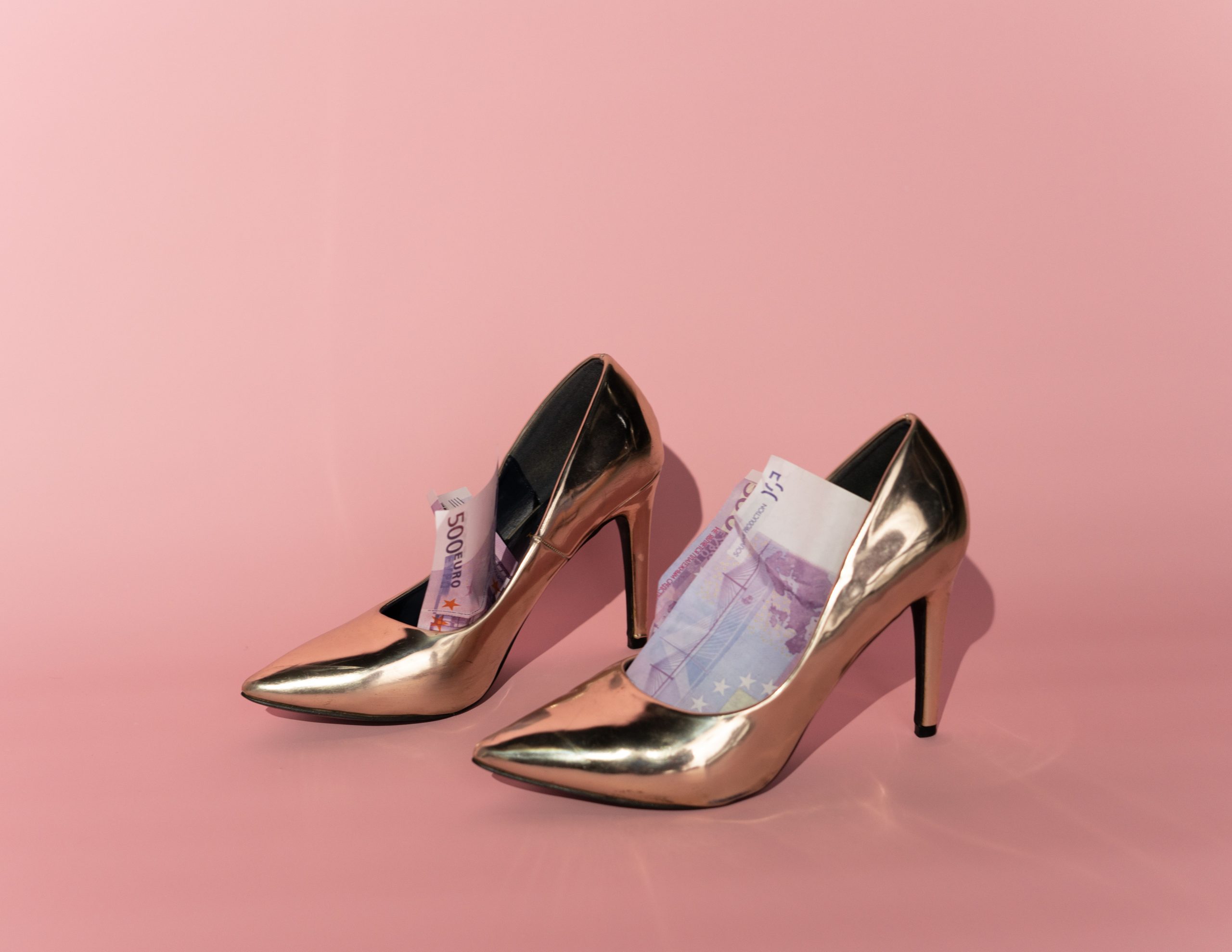 Talons dorés remplis billets euros fond rose