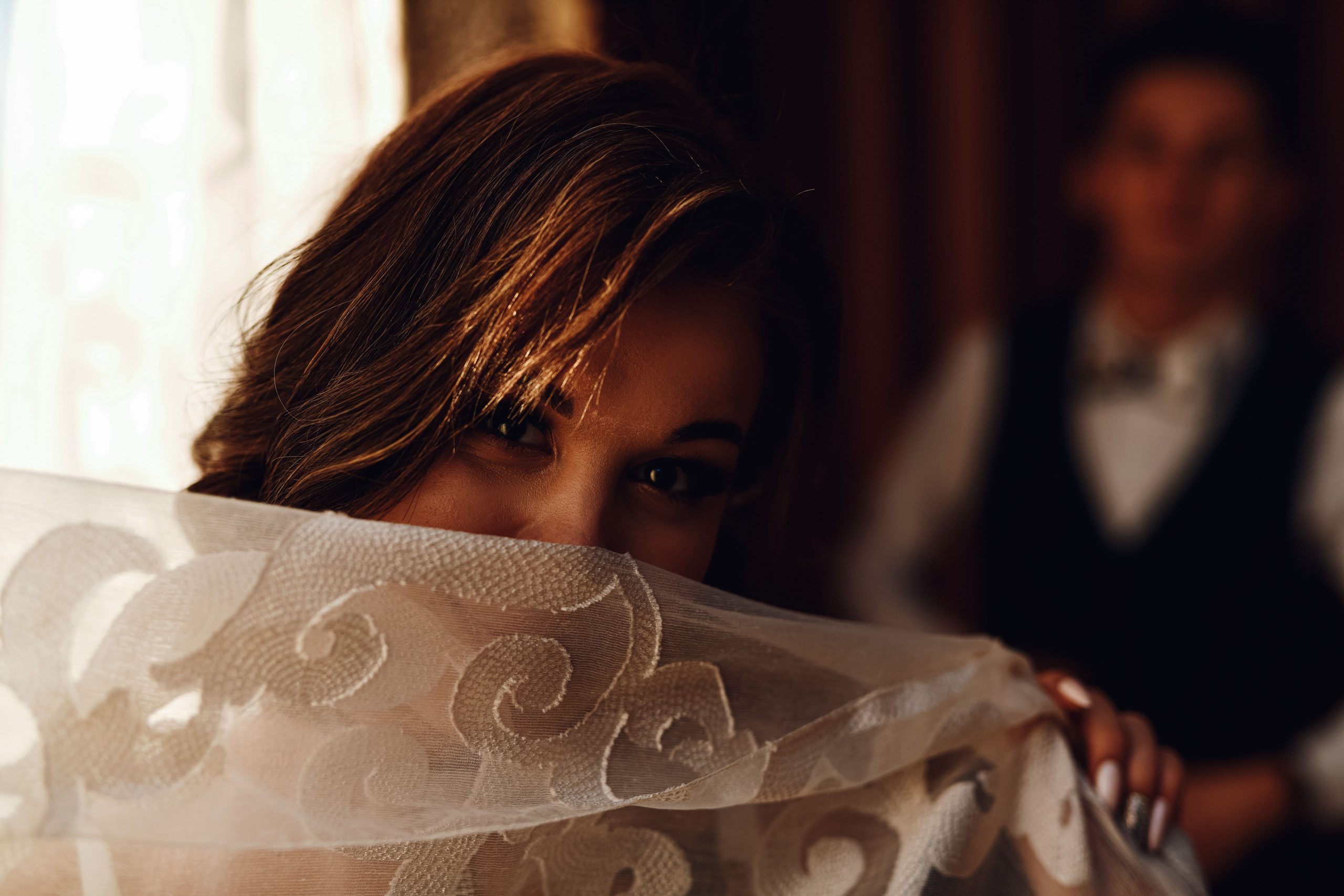Femme mystérieuse se couvrant le visage de dentelle