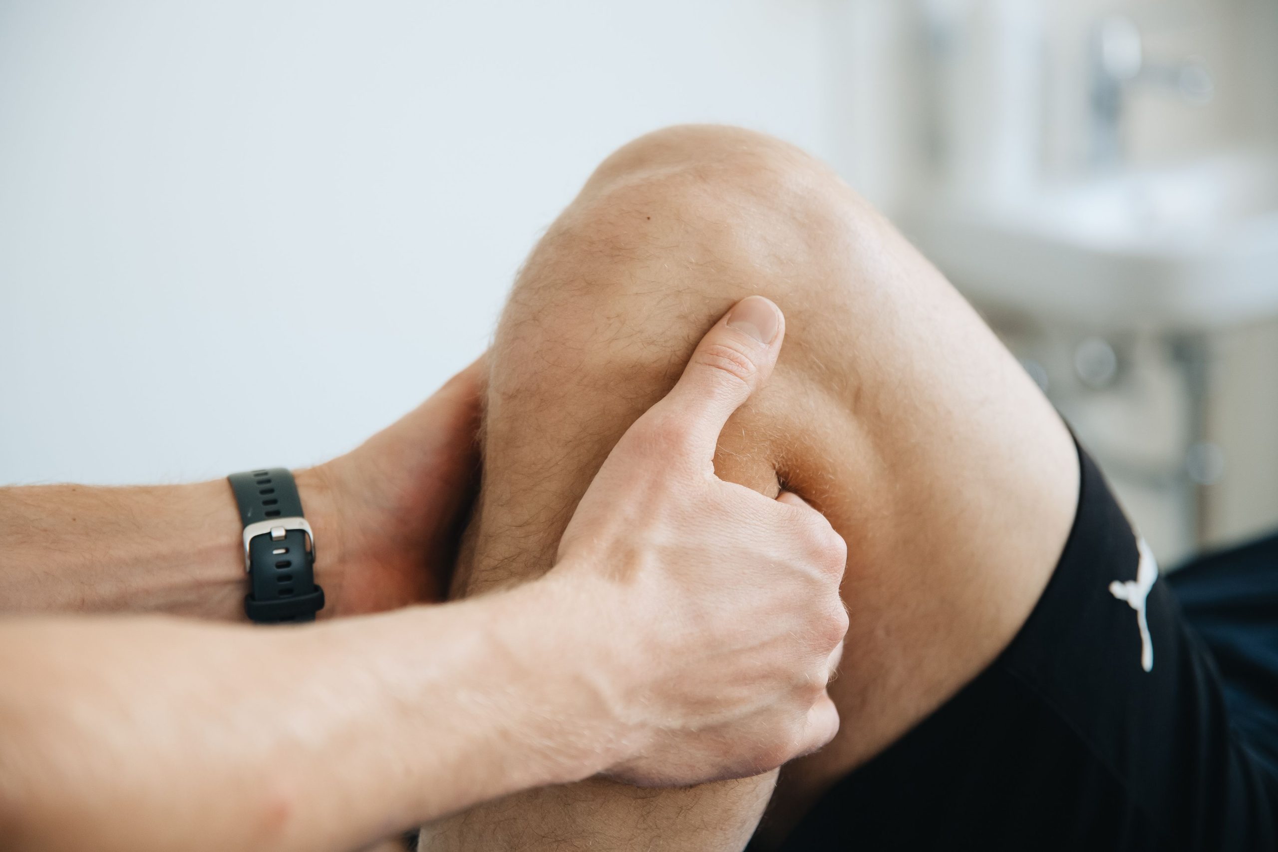 Kinésithérapeute massant le genou du patient