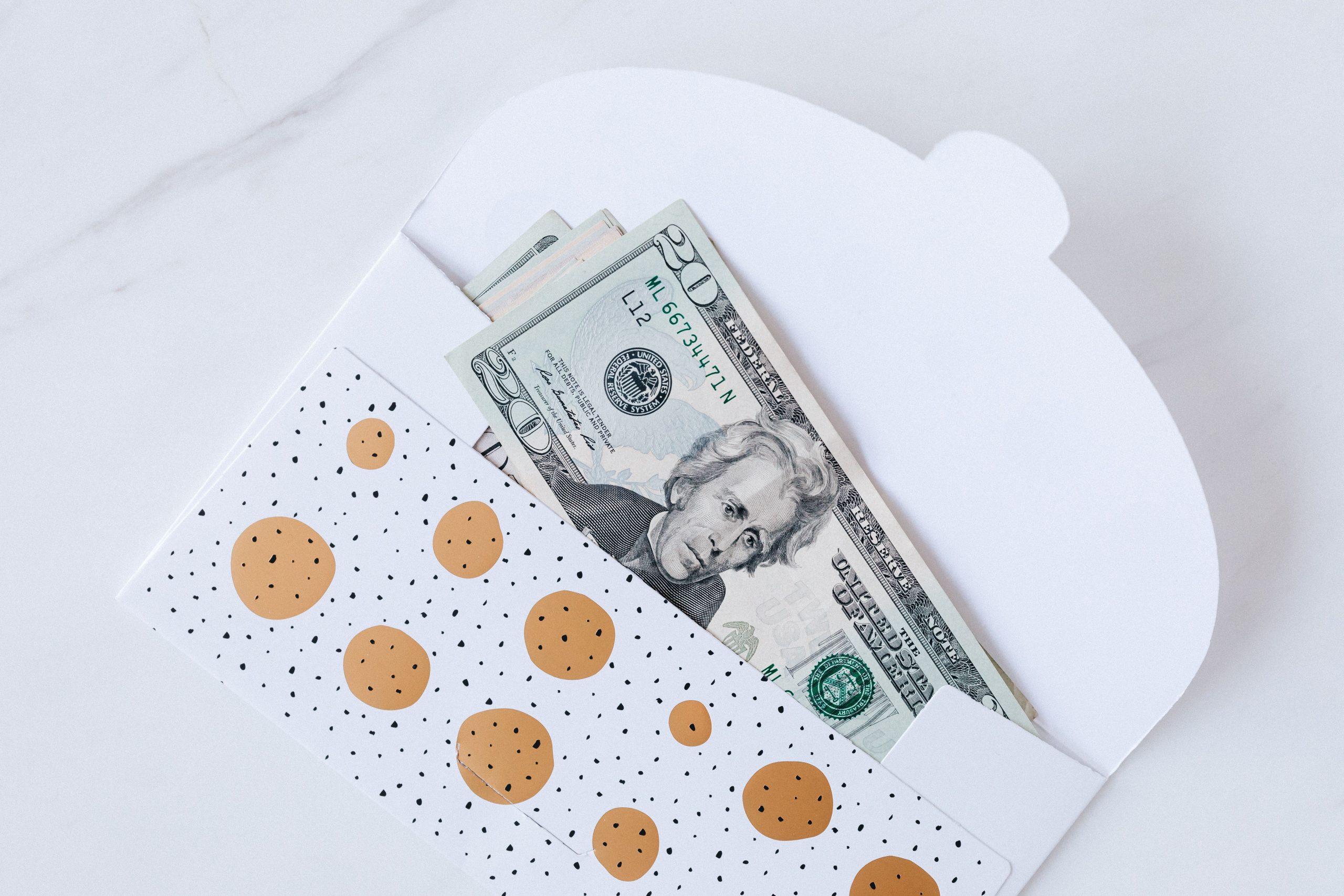 Enveloppe ouverte avec billets argent sur table blanche