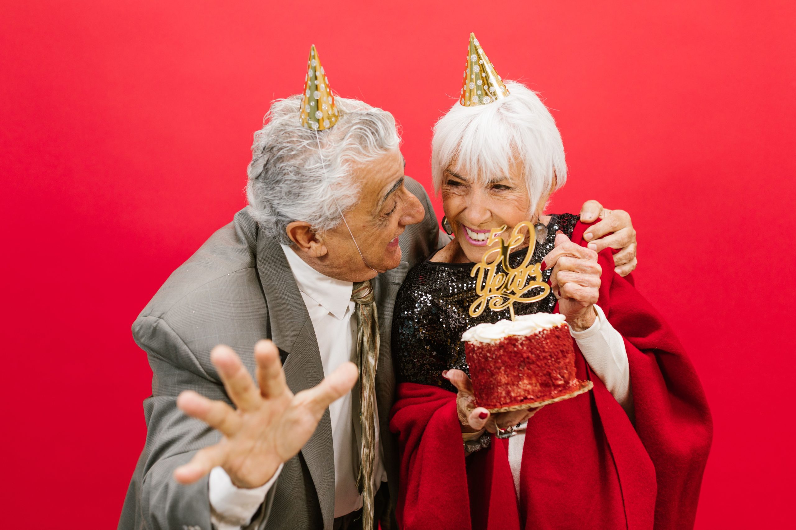 Couple âgé chapeaux fête anniversaire gâteau joie