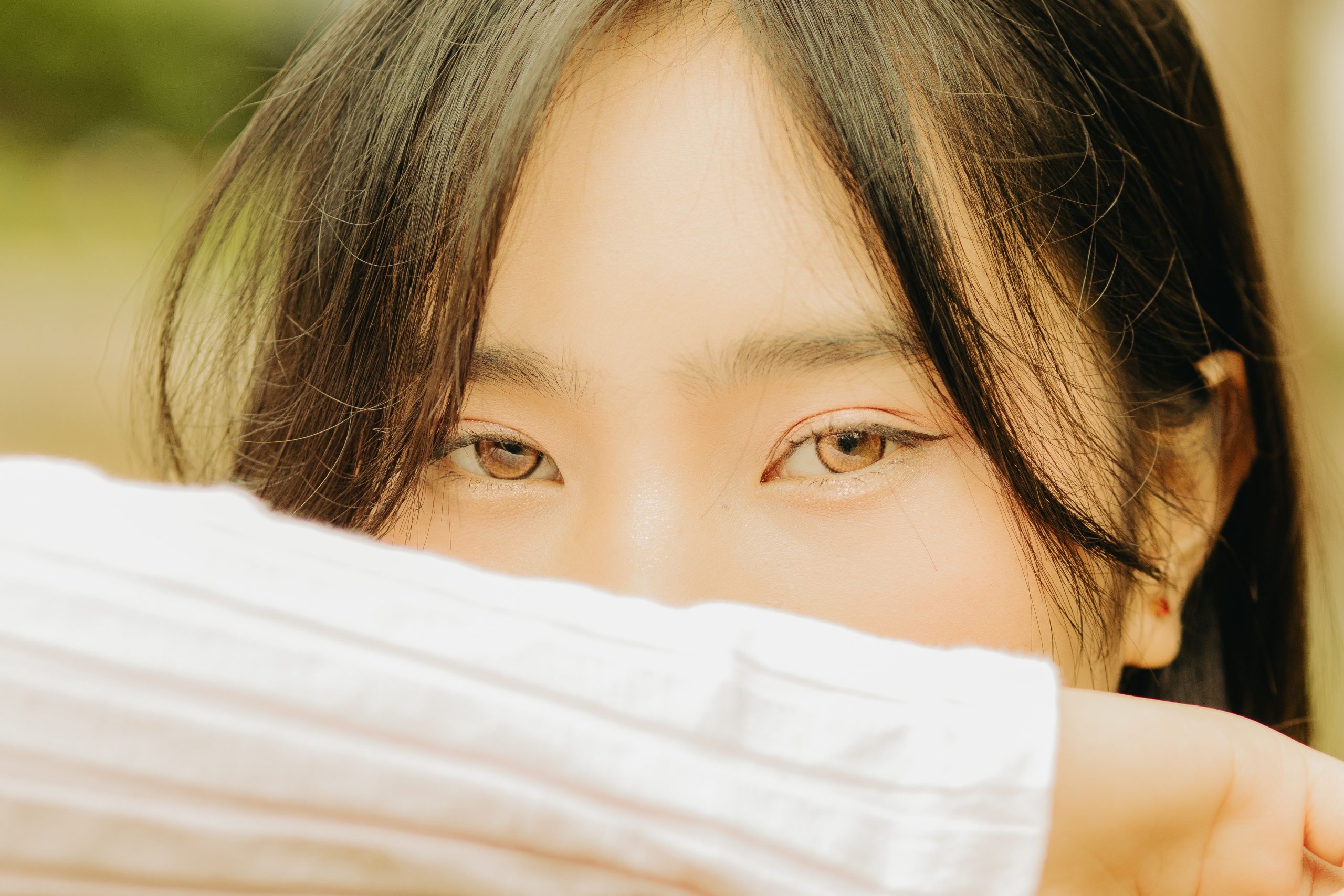 Jeune femme aux yeux expressifs se cachant